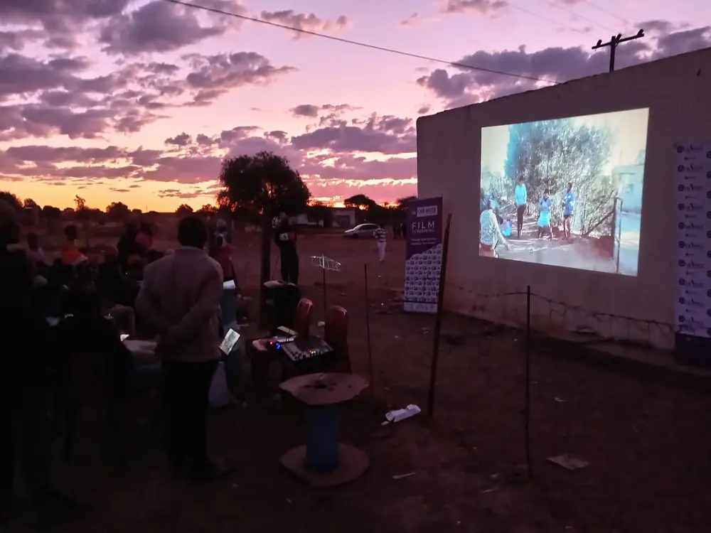 Open-air Our Voice film screening at dusk in a Northern Cape community